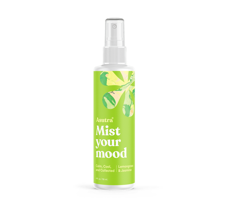 A white spray bottle labeled "Calm, Cool, and Collected Aromatherapy Mist" with green and yellow botanical design, featuring lemongrass and jasmine scents.