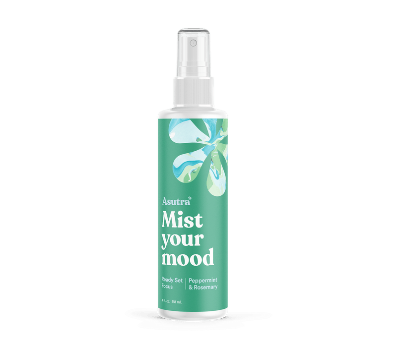 A white spray bottle labeled "Asutra Mist Your Mood" with a green and blue abstract leaf design, containing peppermint aromatherapy mist.