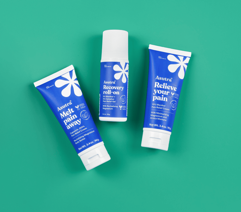 Three Asutra pain relief products on a green background, including a roll-on and two cream tubes for all-day relief.