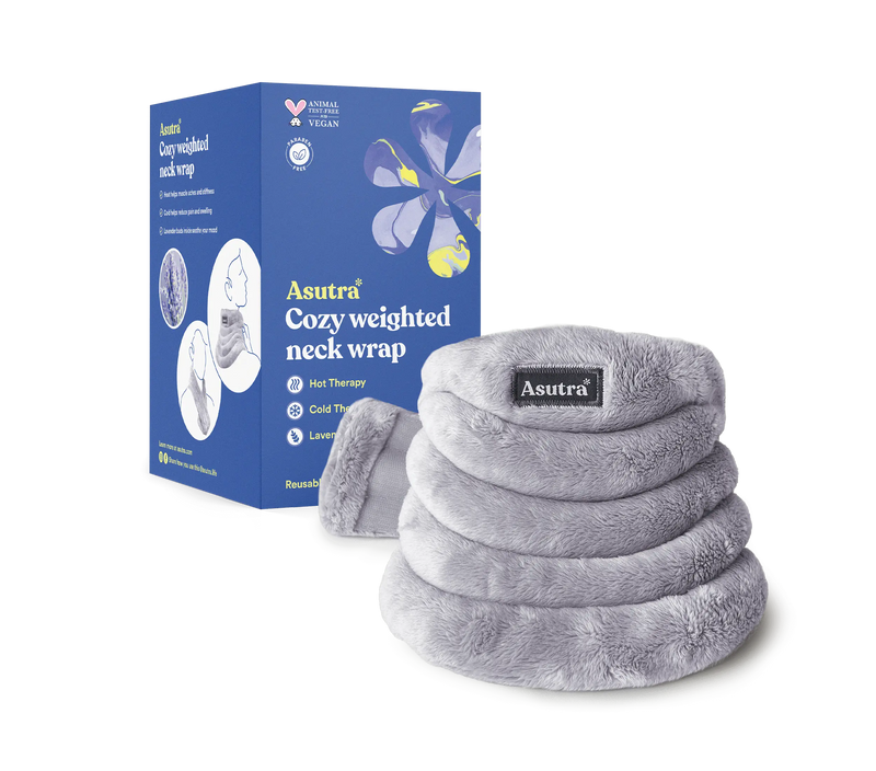 Soft gray plush weighted neck wrap with a black Asutra label, designed for hot or cold therapy, placed next to its blue packaging box.