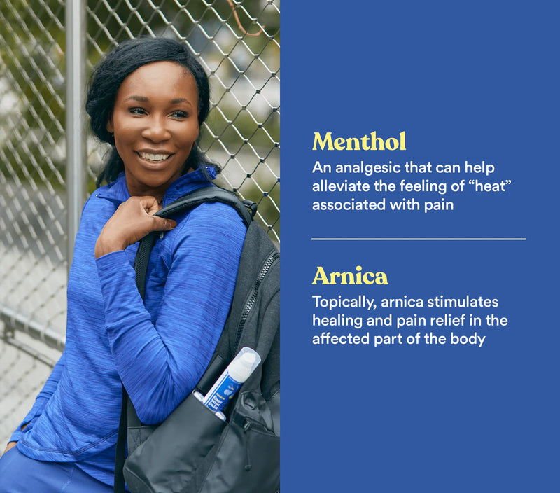 Woman with a backpack holding a menthol & arnica pain relief gel, smiling outdoors near a chain-link fence.