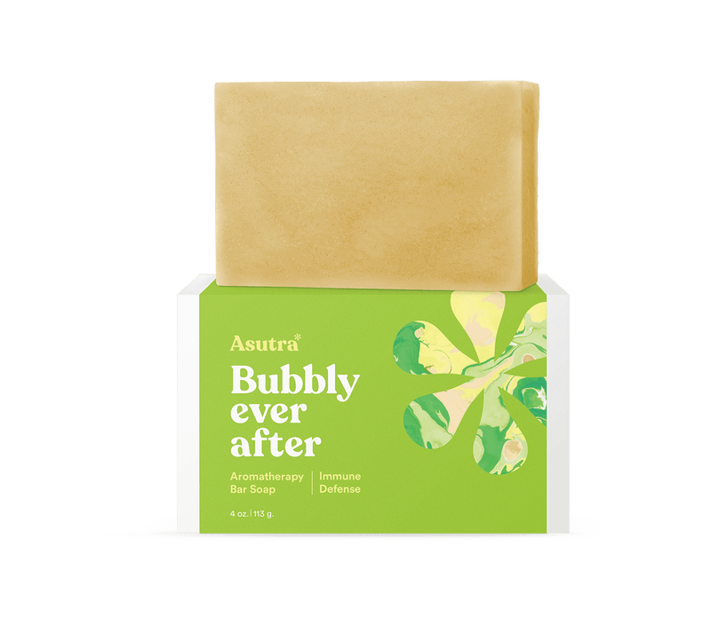 Bar soap labeled "Asutra Bubbly Ever After" with green and yellow packaging, designed for immune defense and aromatherapy.