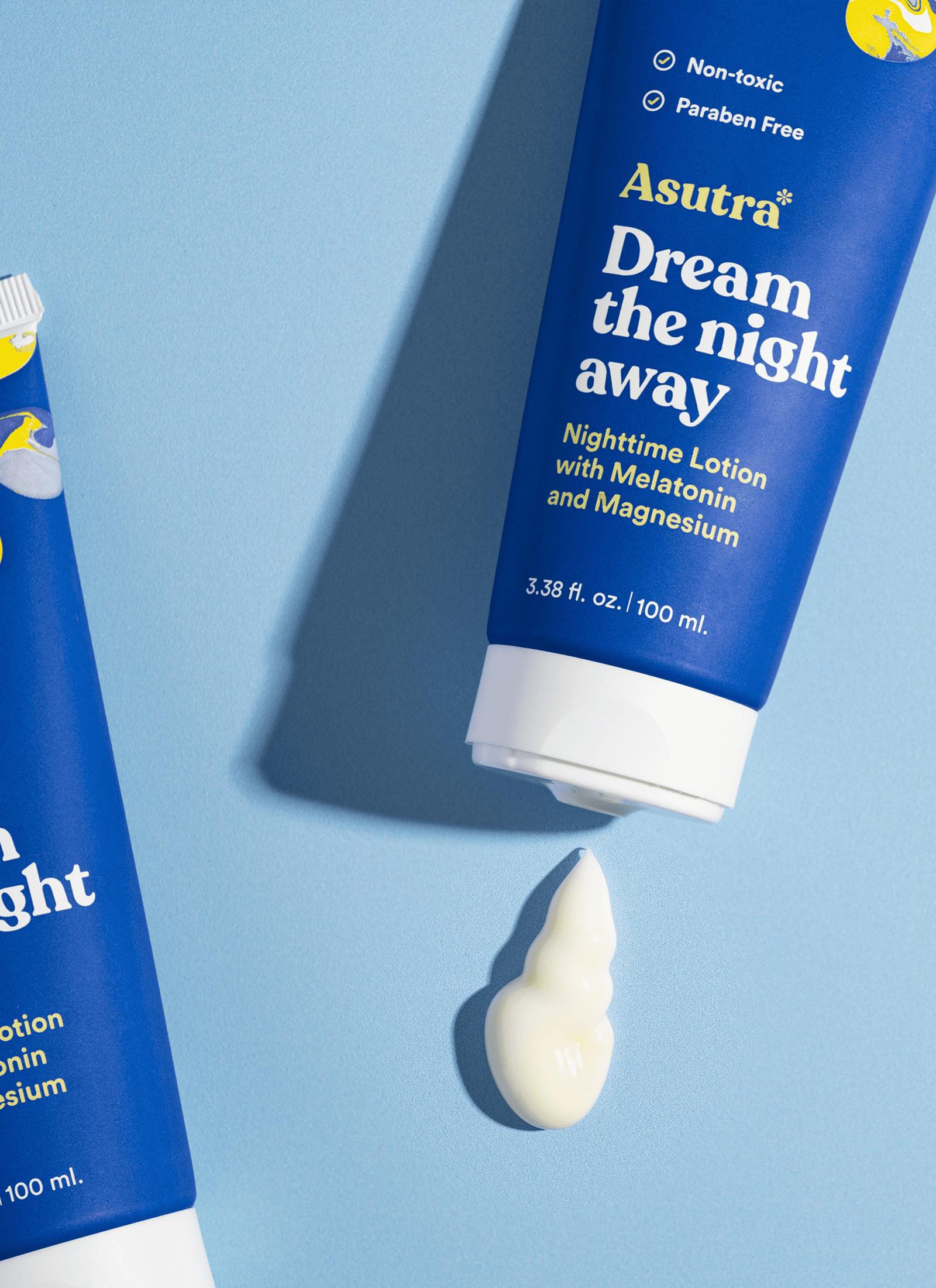 Asutra Dream the Night Away lotion on a light blue background, with one tube showing a dollop of lotion.