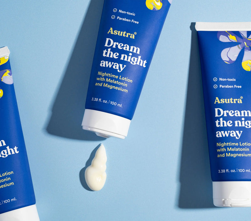 Blue tubes of Asutra Melatonin Lotion with Magnesium, labeled as non-toxic and paraben-free, on a light blue background.