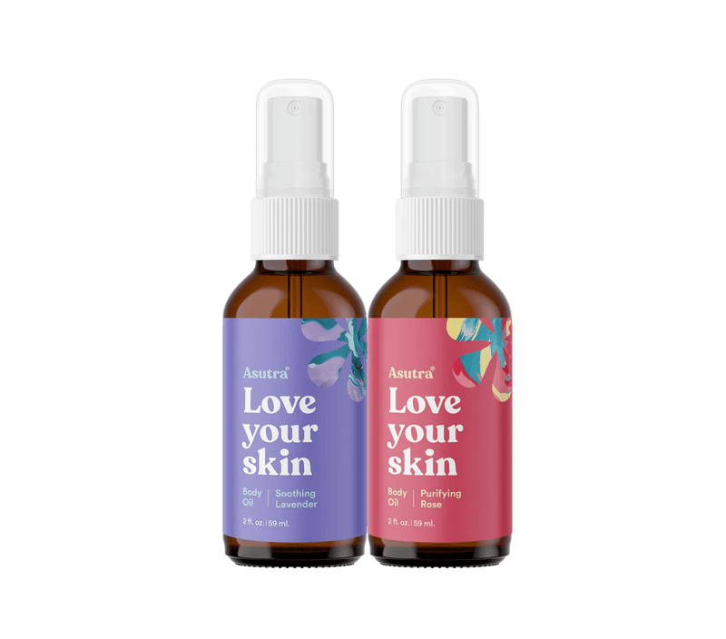 Two 2 oz. amber glass bottles of body oil with spray tops, labeled "Love Your Skin" bundle—lavender soothing and rose purifying.