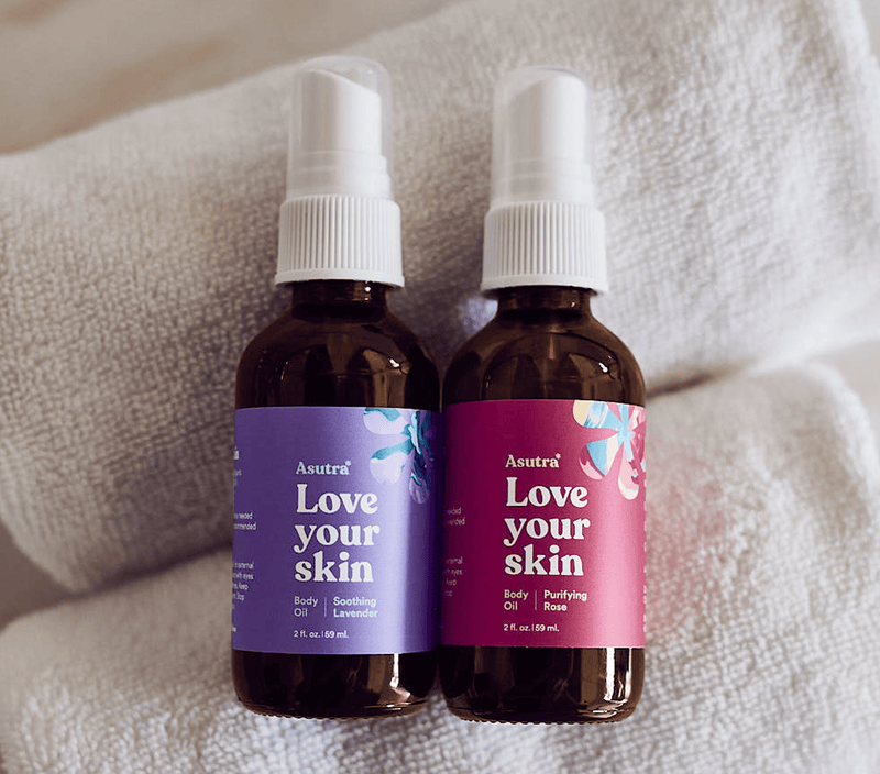 Two 2 oz. brown glass spray bottles of Rose and Lavender Body Oil Bundle with white spray caps, labeled "Love your skin.