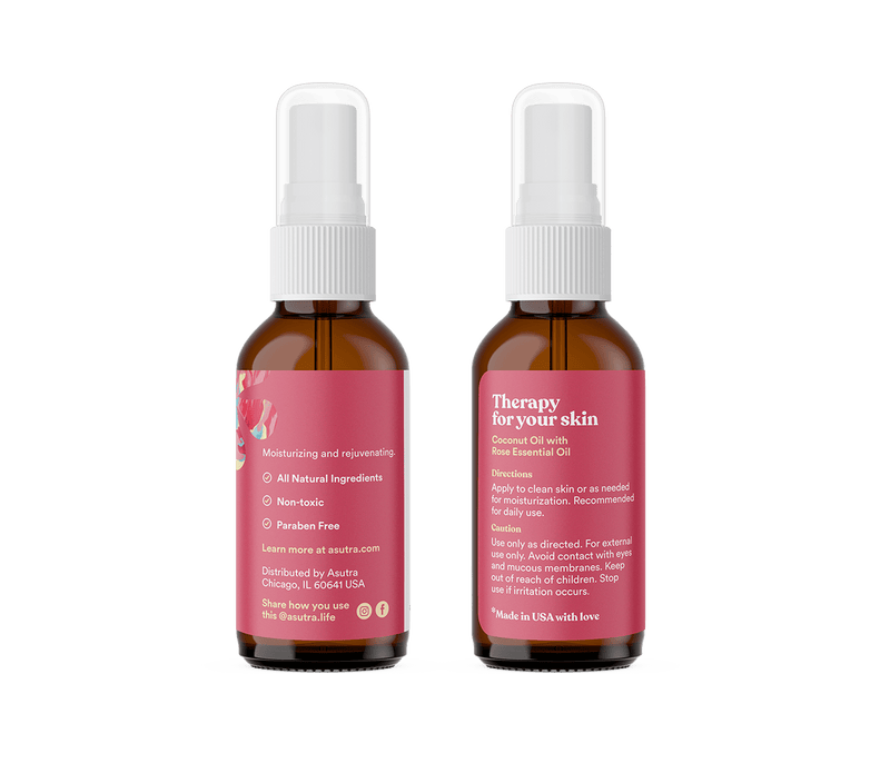 Amber glass bottles with white spray caps containing rose body oil, featuring pink labels with product details and usage instructions.