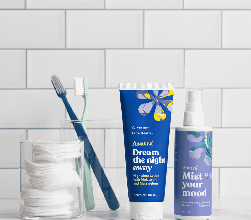 The Ultimate Sleep Bundle includes a purple eye pillow, Dream nighttime lotion, mist spray, and lavender body oil on a bathroom shelf.