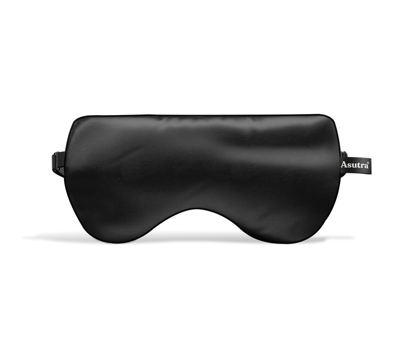 Black silk eye pillow with an Asutra tag, designed for relaxation and sleep.