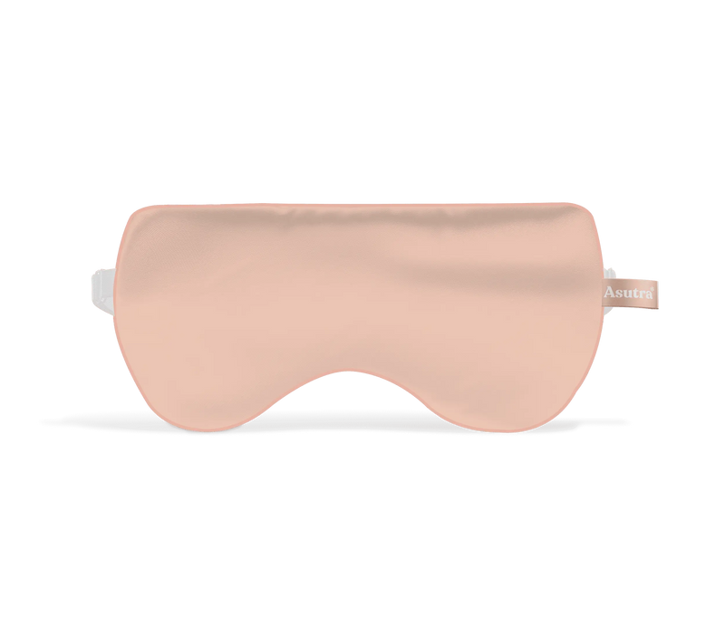 Pink silk eye pillow with a smooth, shiny surface and a small fabric tag on the side.