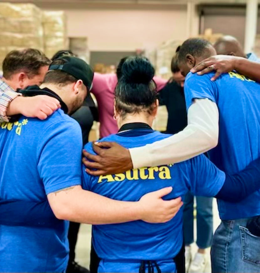 Asutra employees huddle together for a team meeting. 