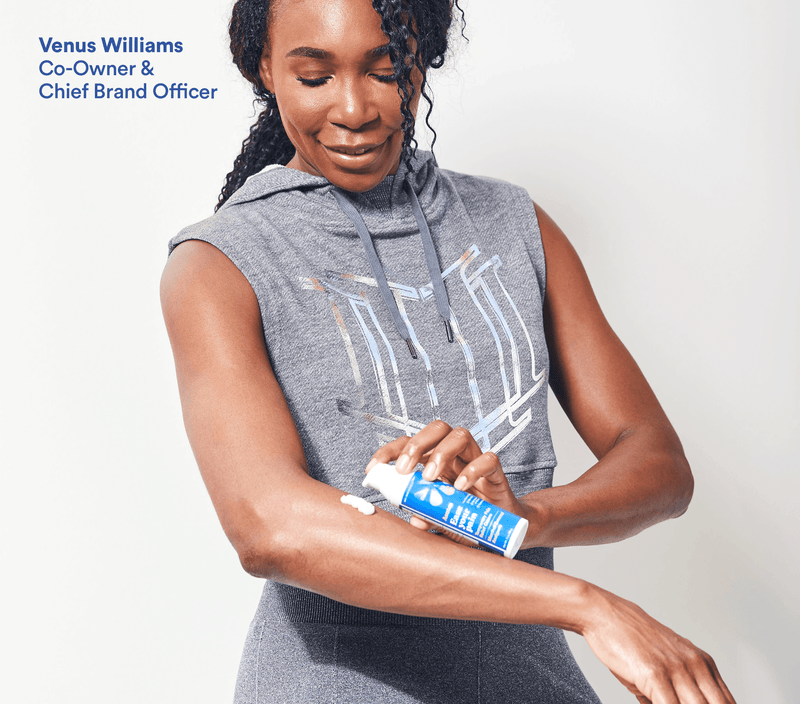 Venus Williams applies Ease Your Pain cream to her arm while wearing workout attire.